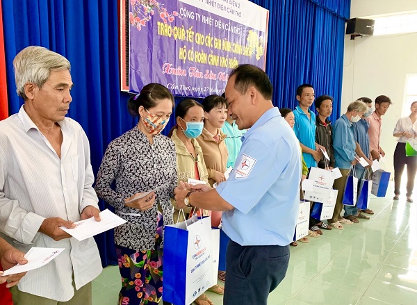 Ông Nguyễn Phước Minh (bên phải), Phó Chủ tịch Công đoàn Công ty NĐCT tặng quà Tết cho hộ nghèo, gia đình chính sách có hoàn cảnh khó khăn tại phường Phước Thới.